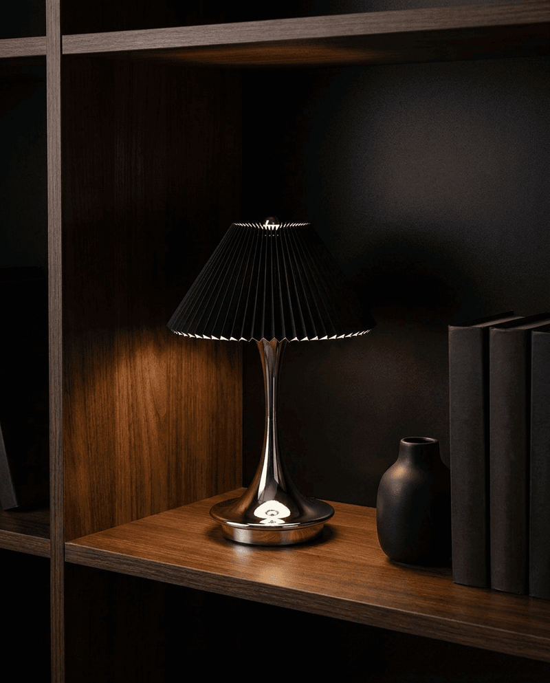 Parisette black lamp styled on a dark bookshelf
